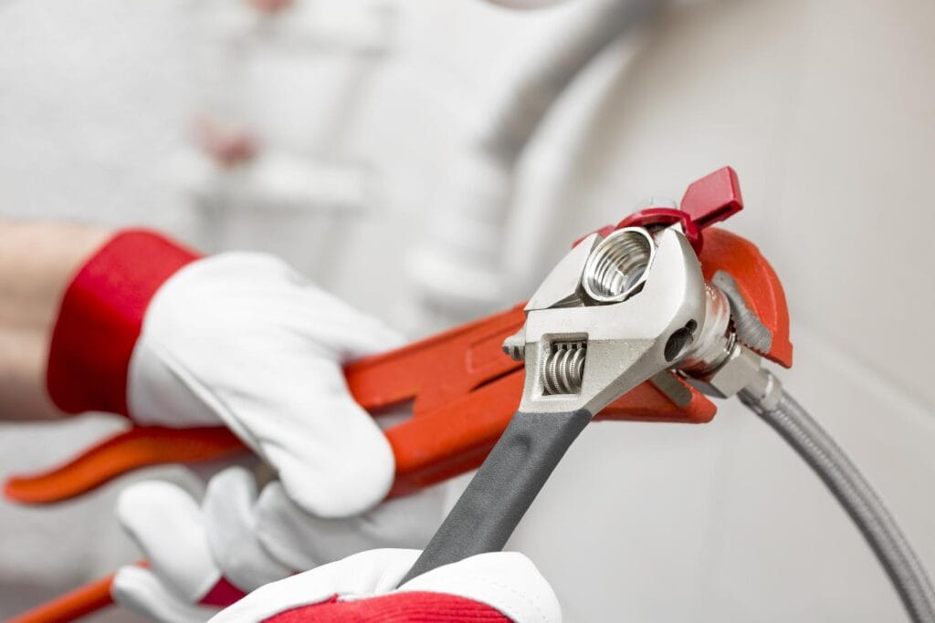 Plumber holding pipe wrenches for an emergency repair in Navarre