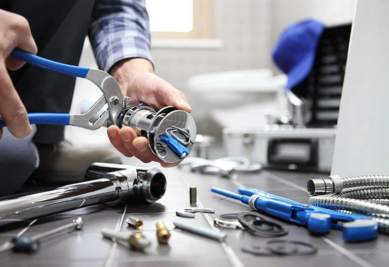 Technician repairing a plumbing fixture with professional tools in Navarre