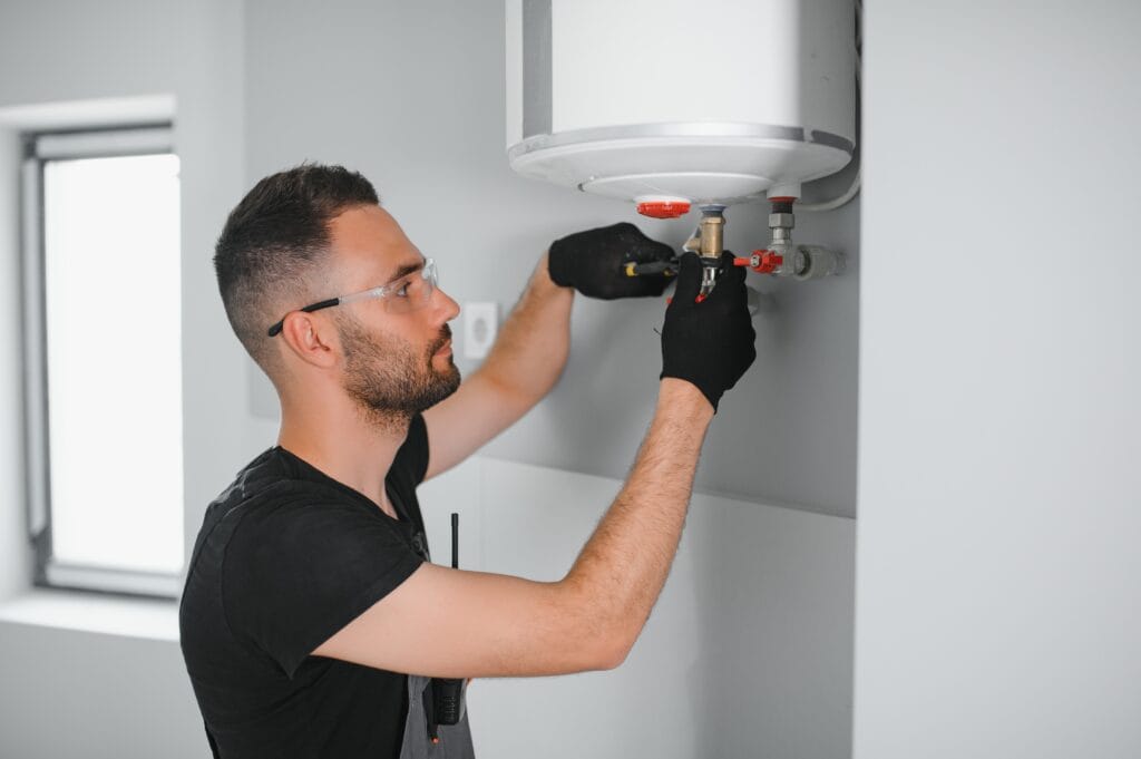Technician performing water heater maintenance in Navarre