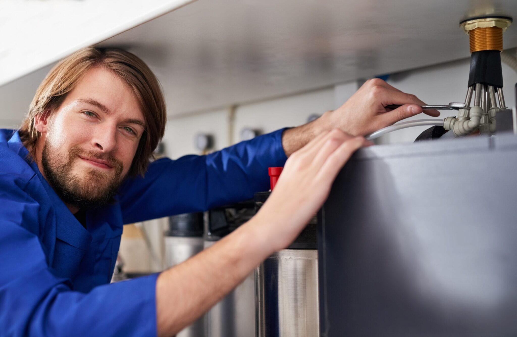 Technician servicing a residential water heater tank in Navarre